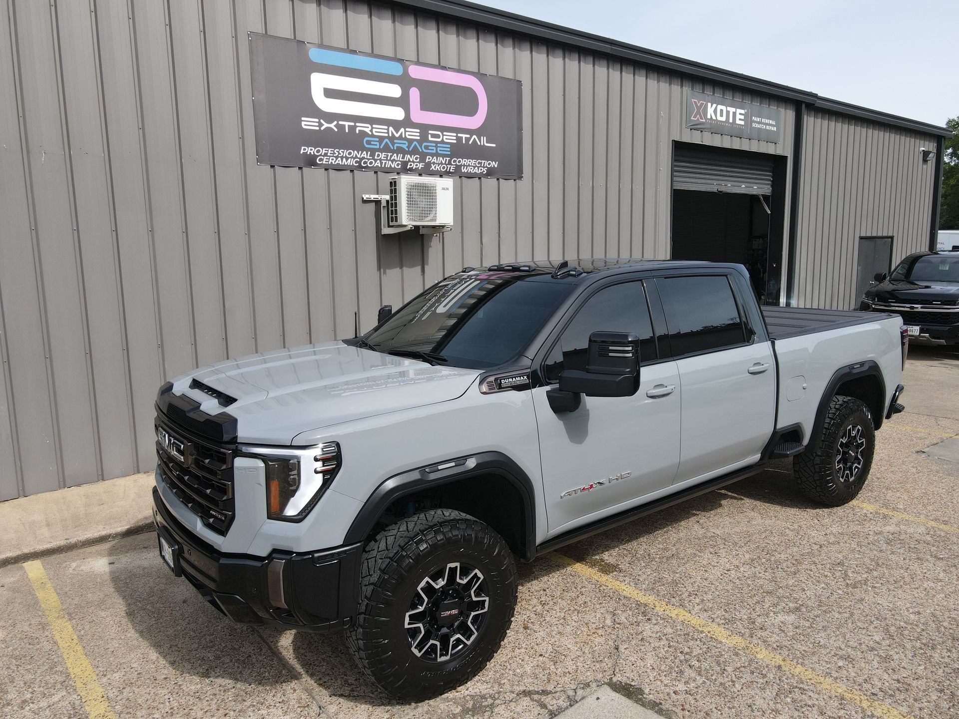 A gray truck is parked in front of a building.