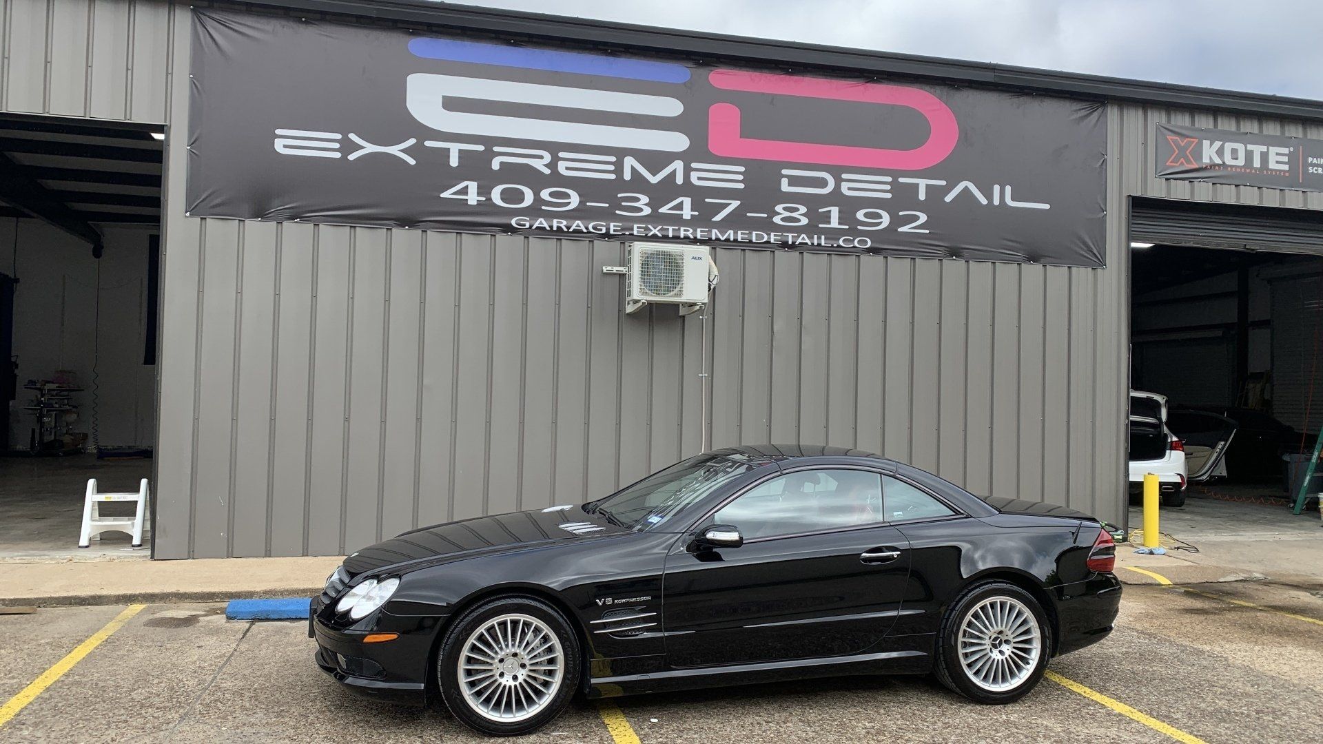 A black sports car is parked in front of a building.