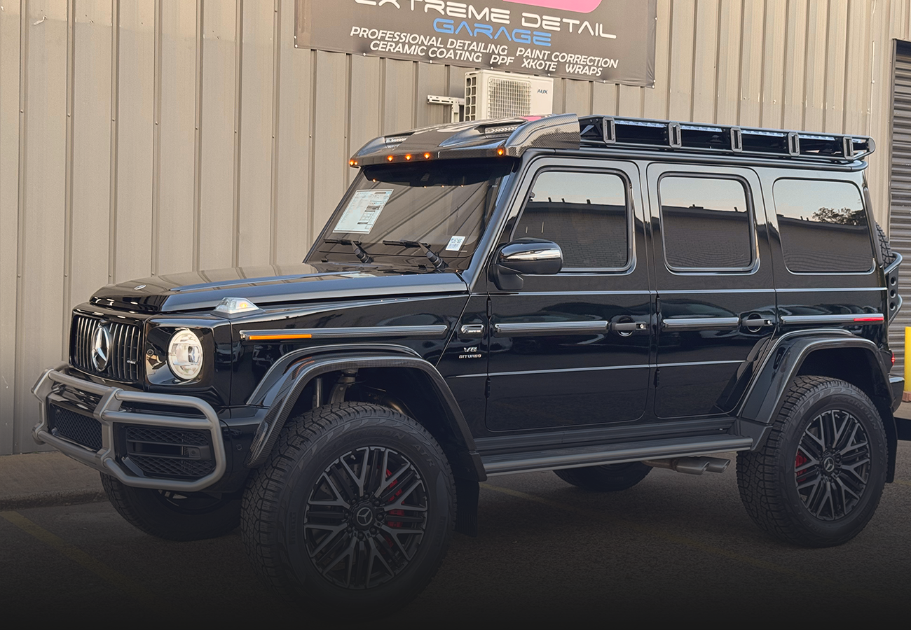 A black jeep is parked in front of a building.