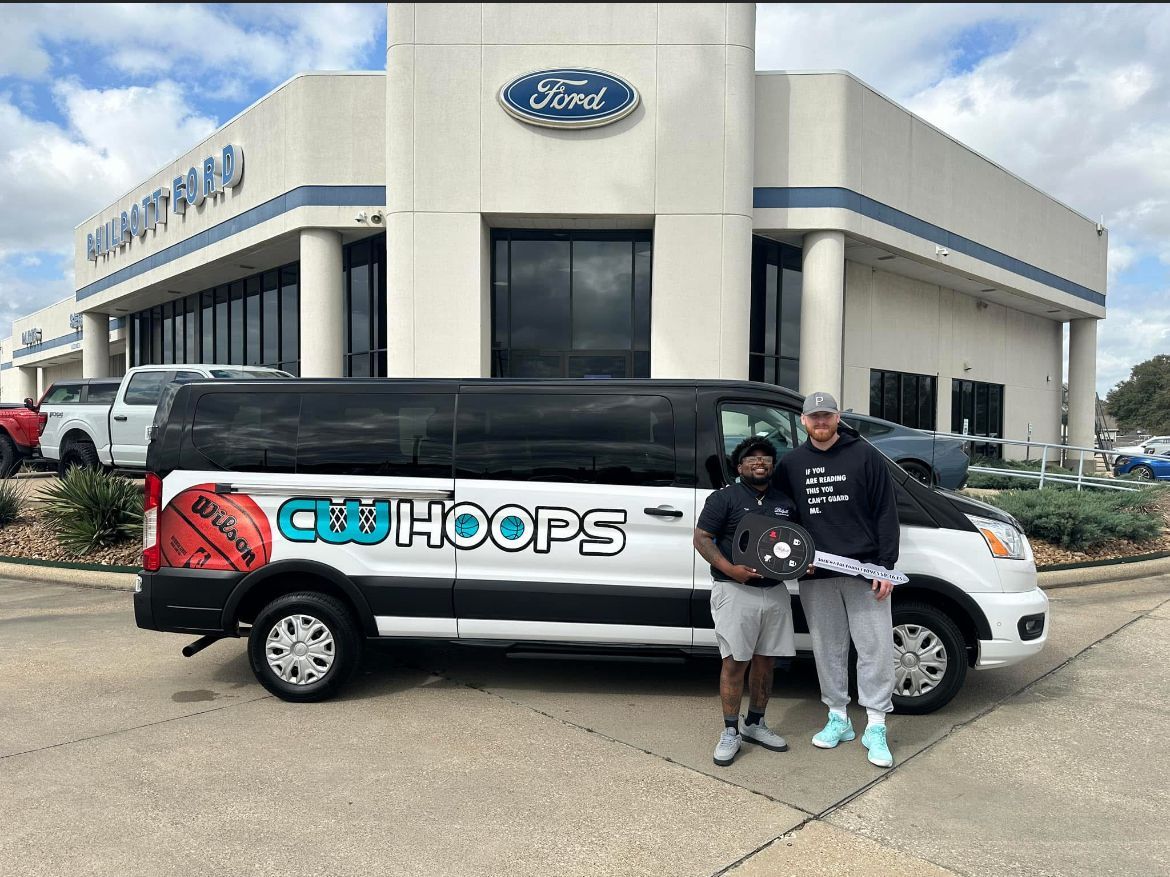 Two men are standing in front of a ford van.