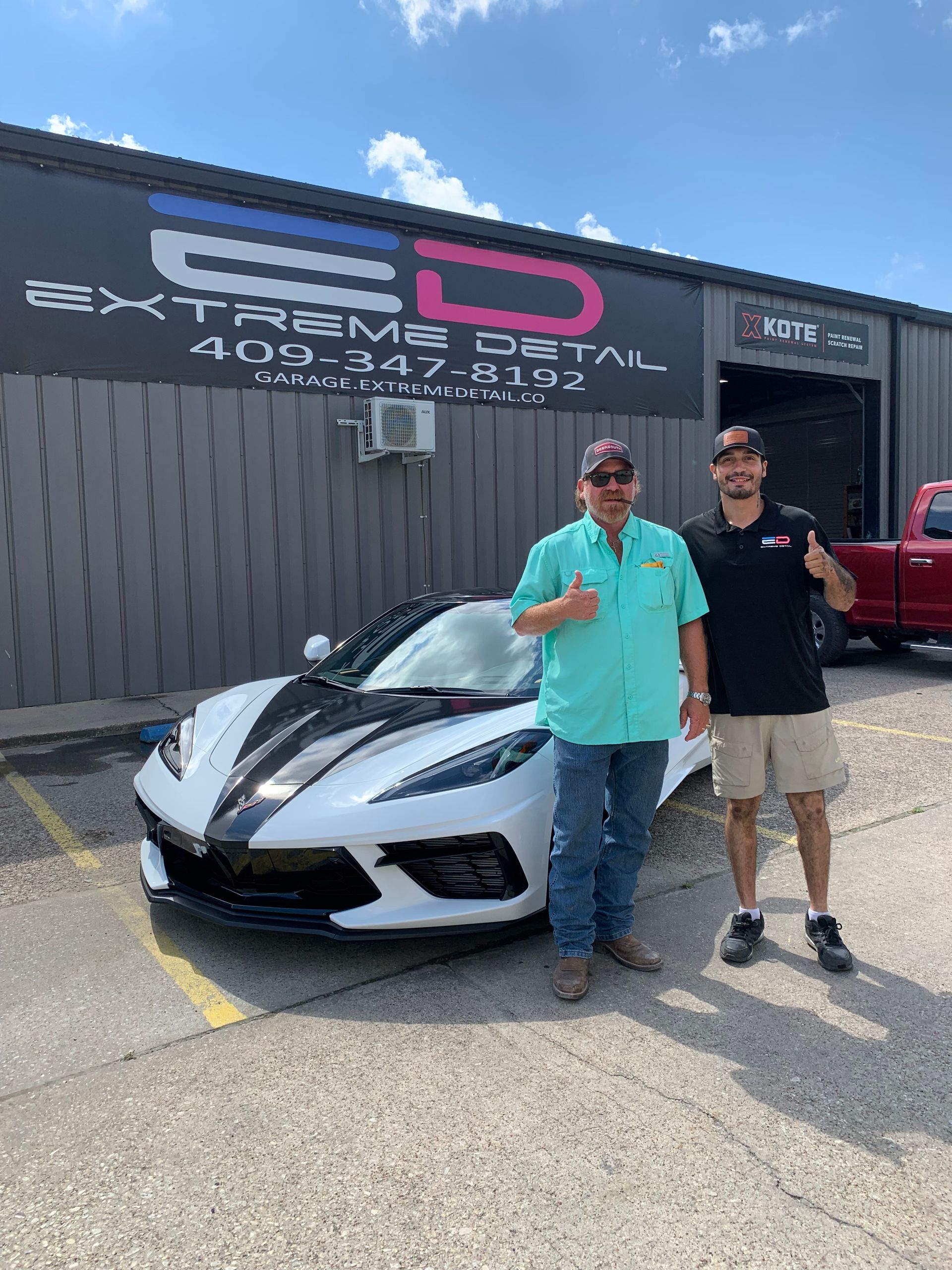 Two men are standing in front of a white sports car.
