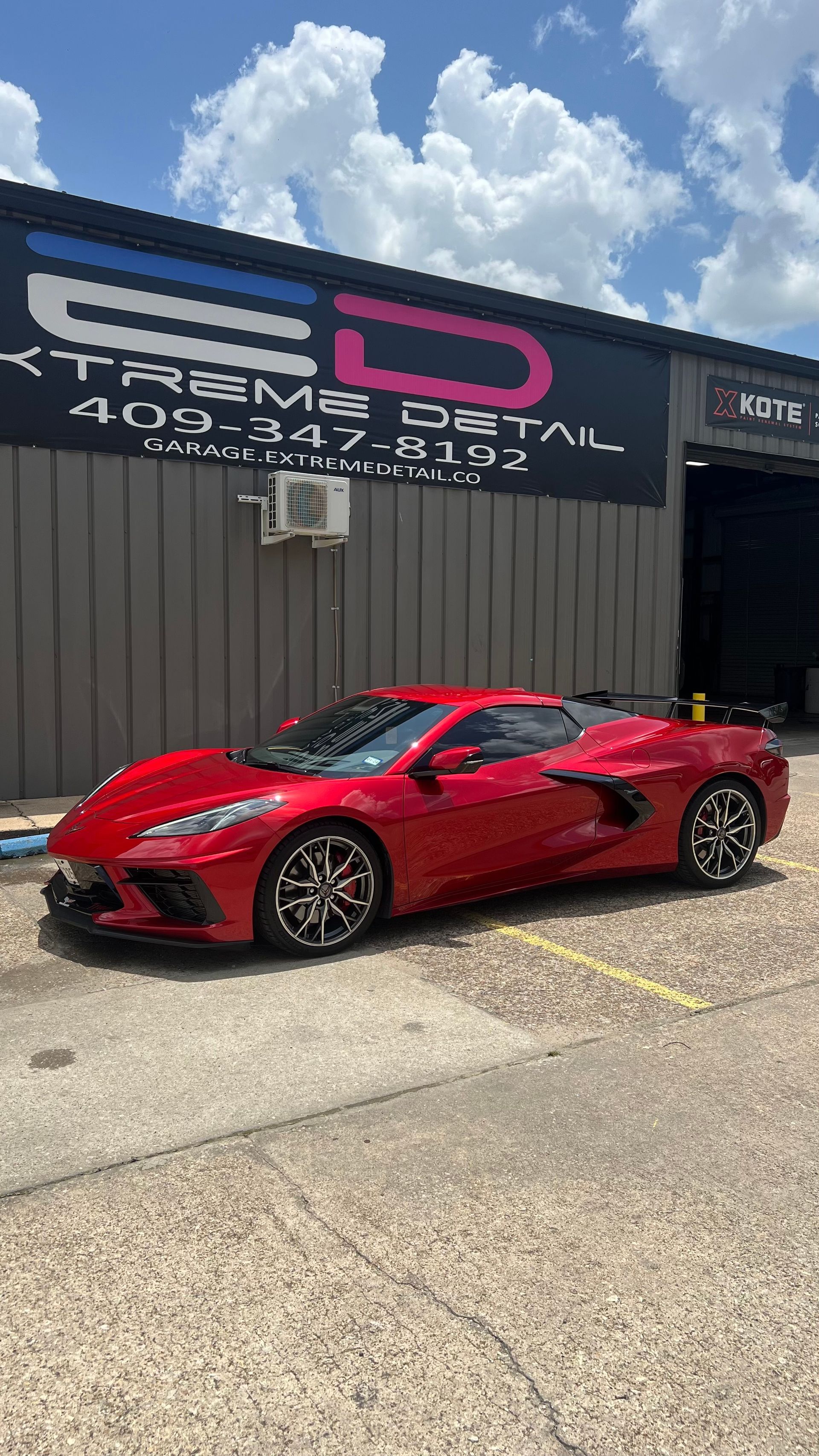 A red sports car is parked in front of a building.