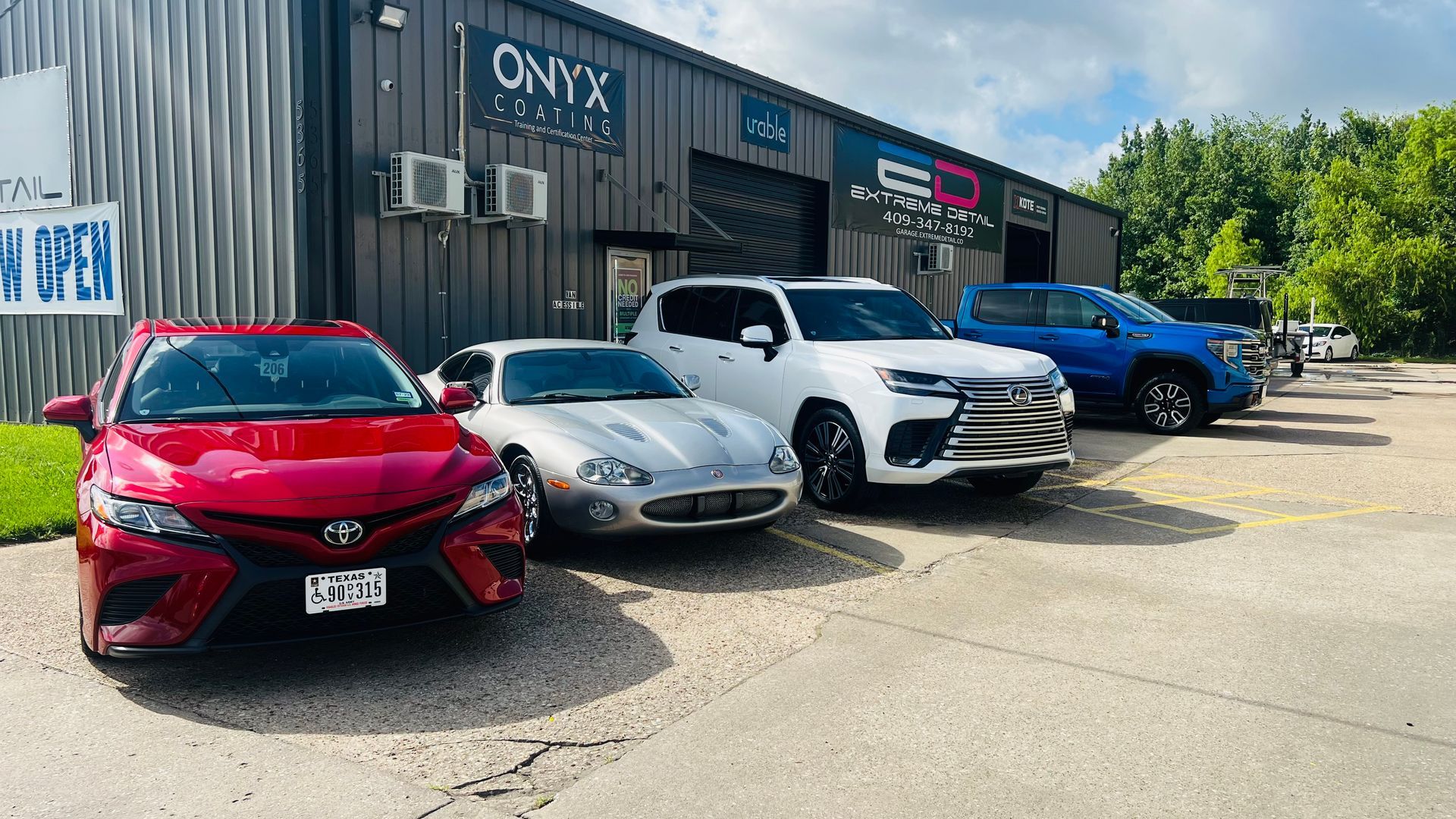 A row of cars are parked in front of a building.