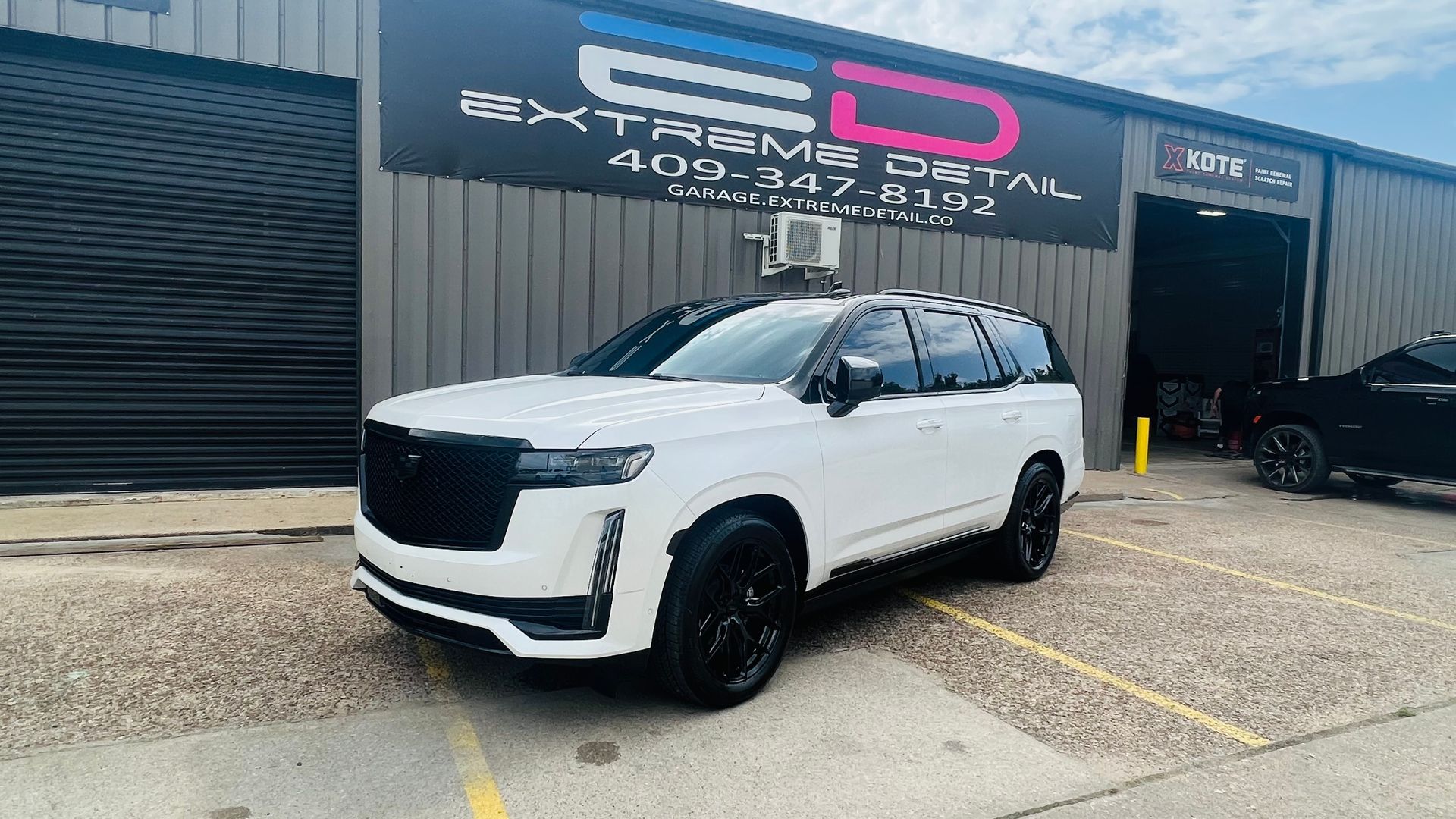 A white suv is parked in front of a building.
