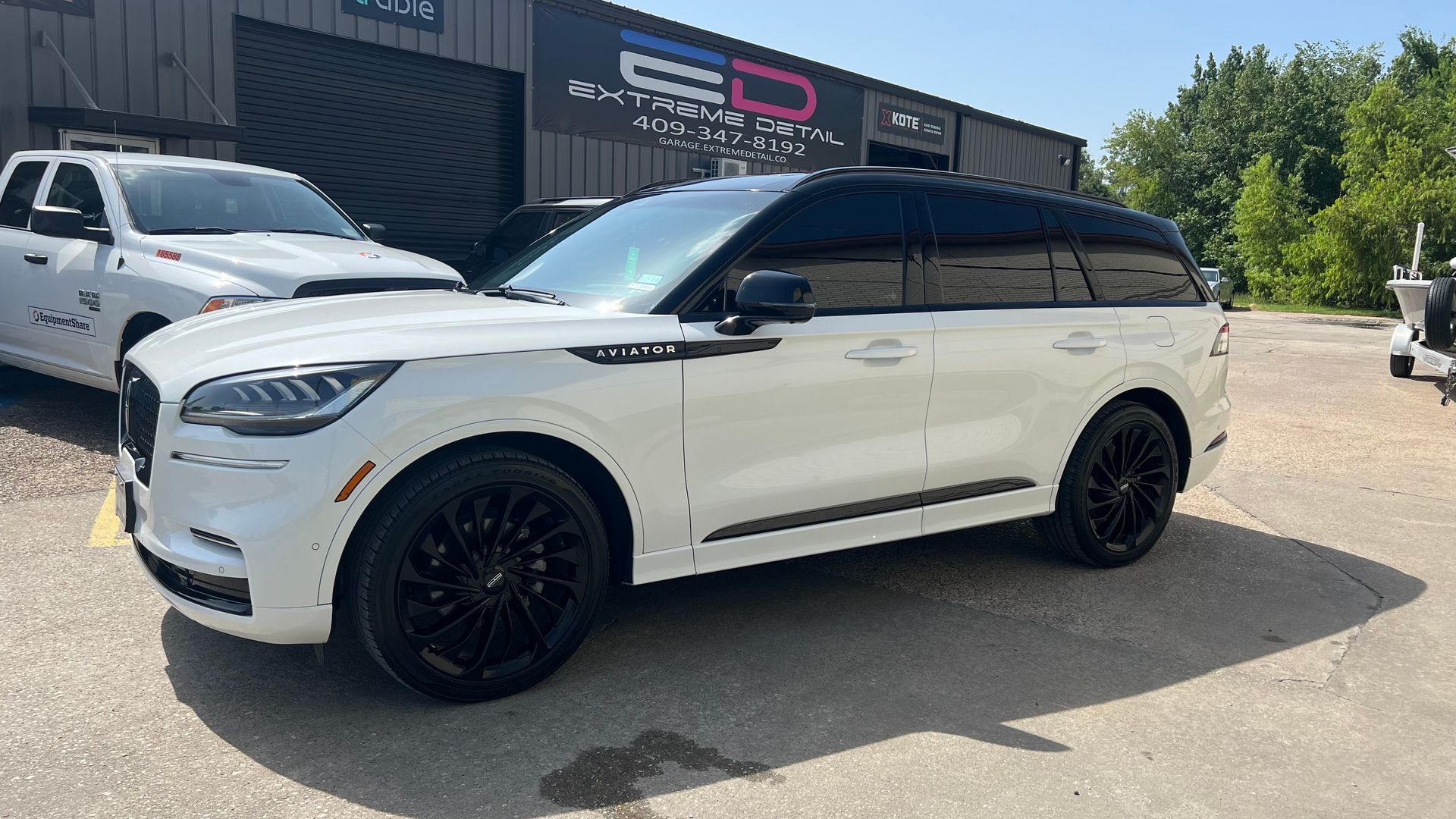 A white ford aviator is parked in front of a building.