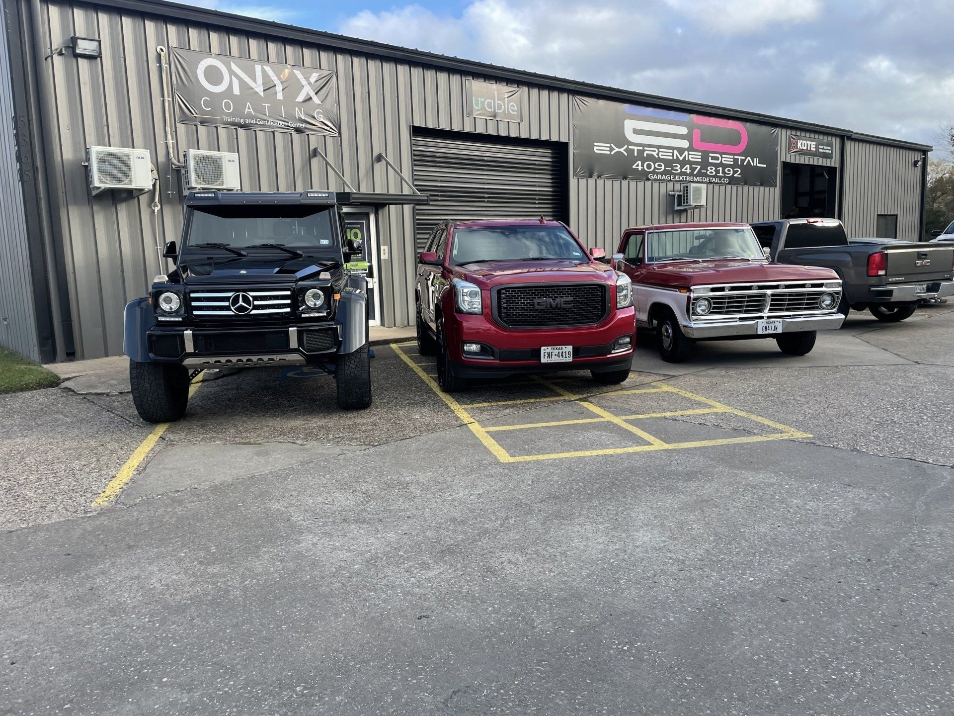 A group of cars are parked in front of a building.