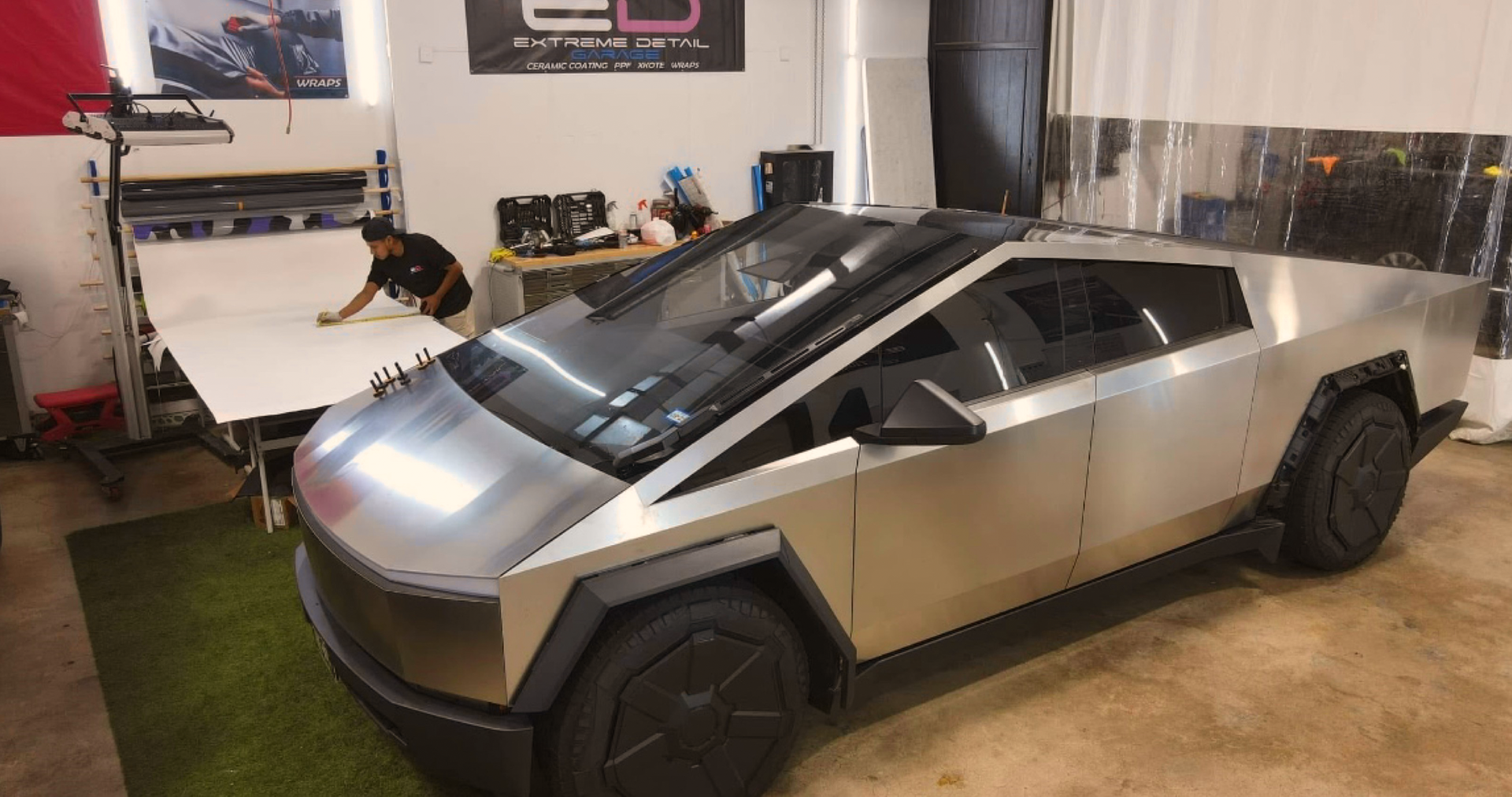 A silver tesla cybertruck is parked in a garage.