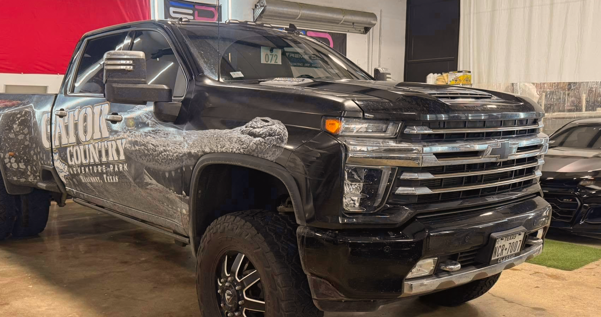 A black truck is parked in a garage.
