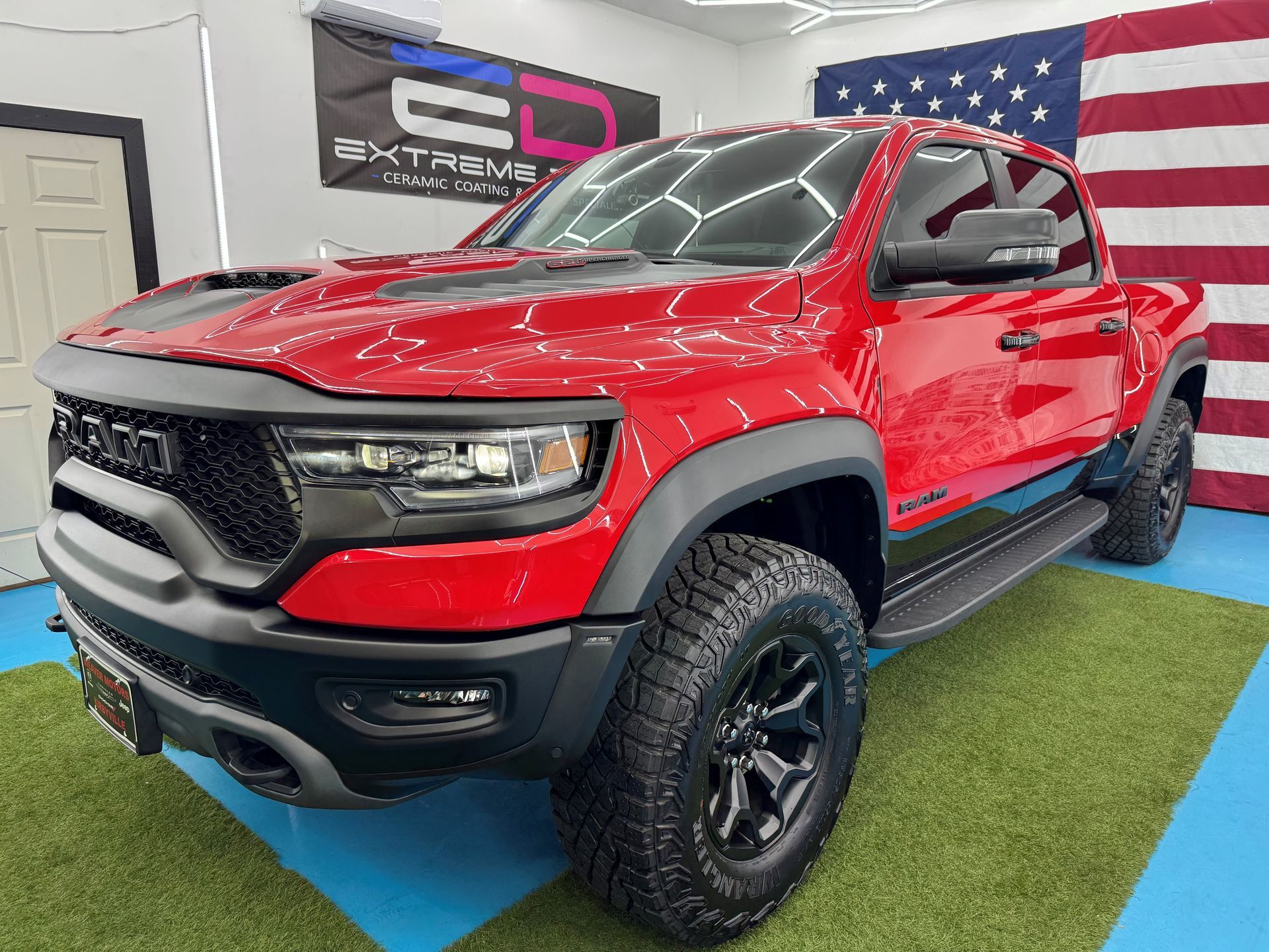 A red ram truck is parked in a car detailing garage