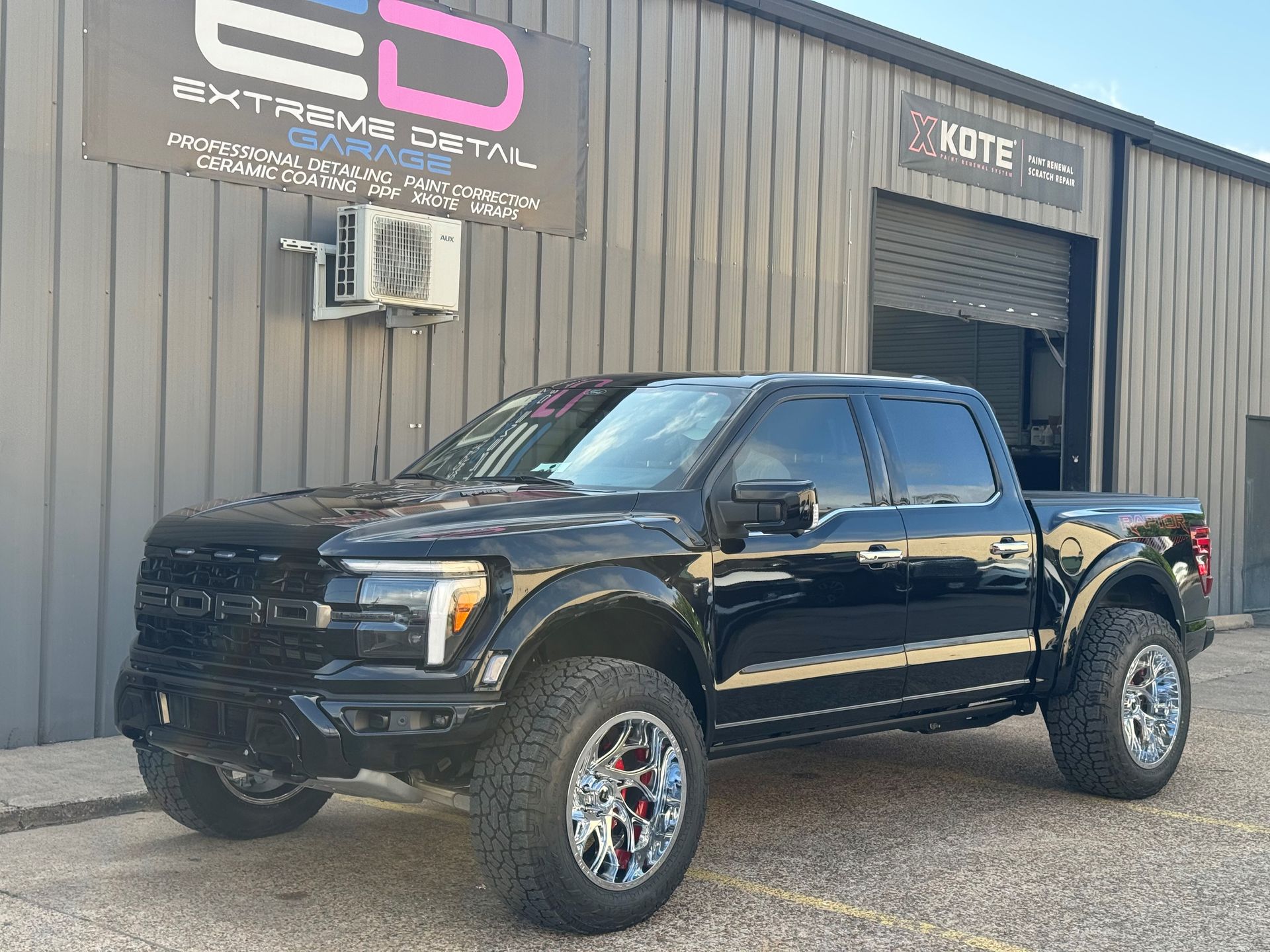 A black pickup truck is parked in front of a building.