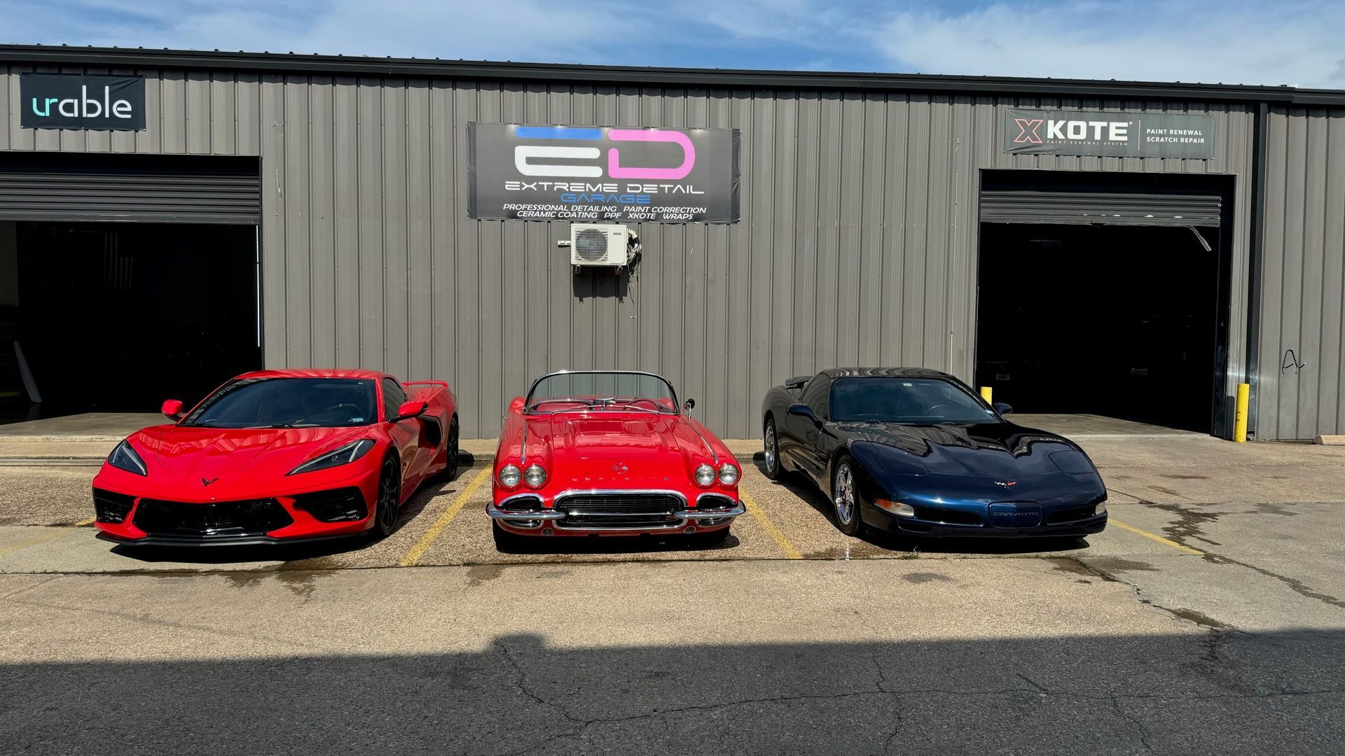 Three sports cars are parked in front of a building.