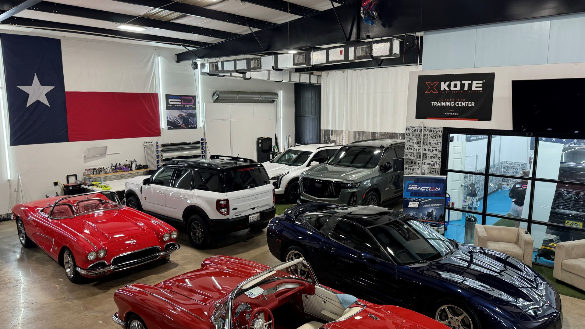 A showroom filled with lots of cars and a texas flag.