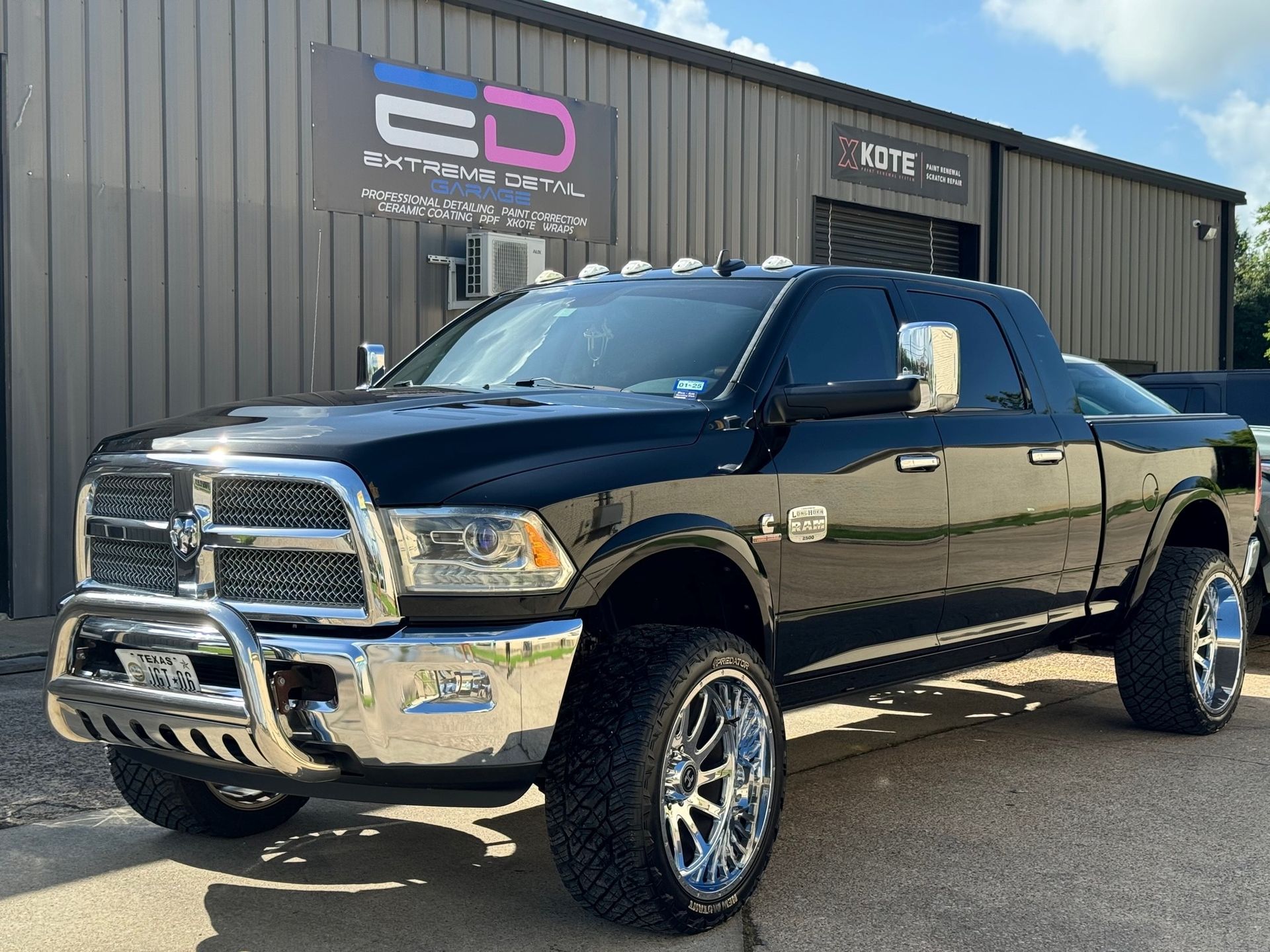 A black dodge ram truck is parked in front of a building.