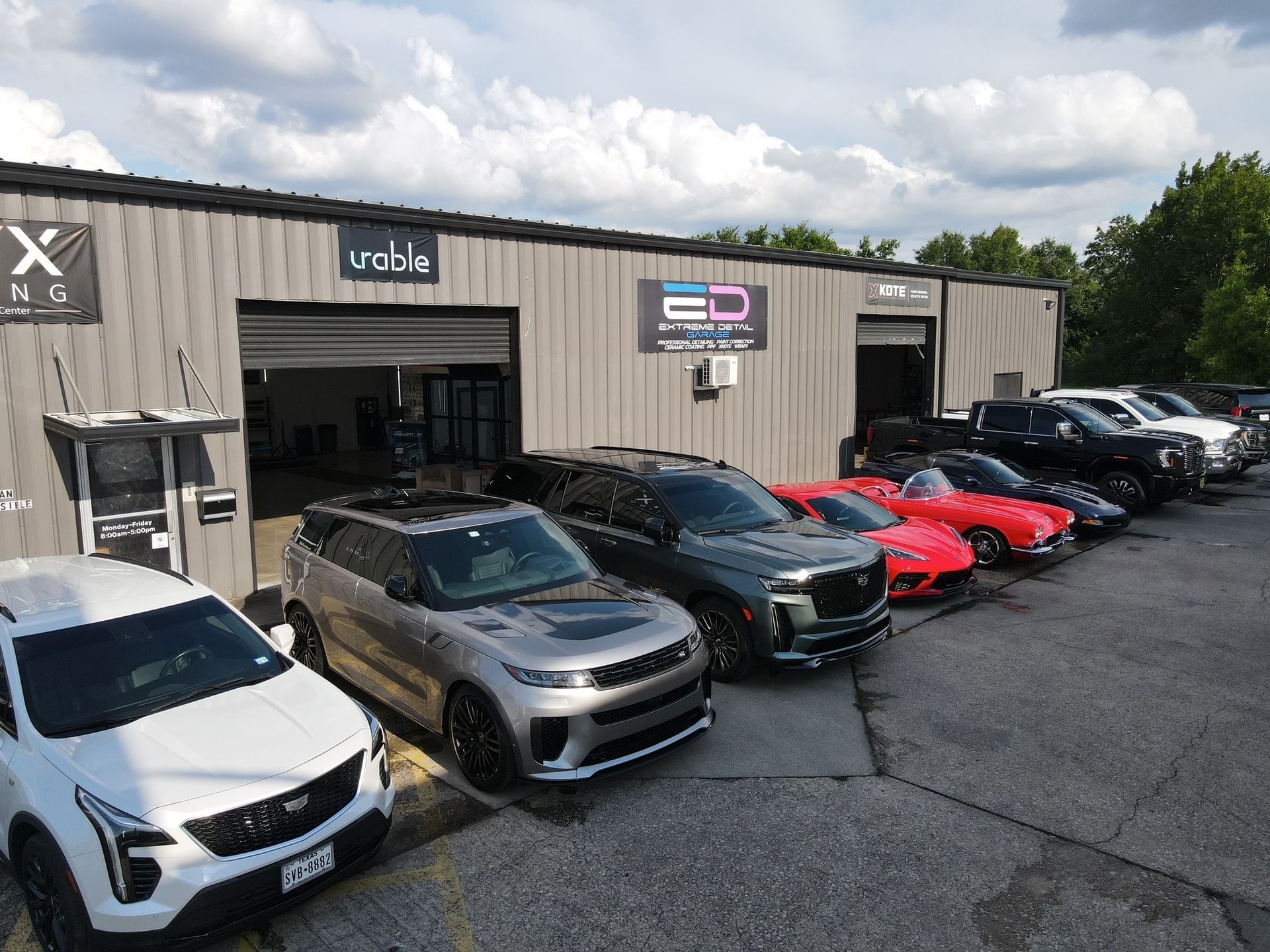 A row of cars are parked in front of a building.
