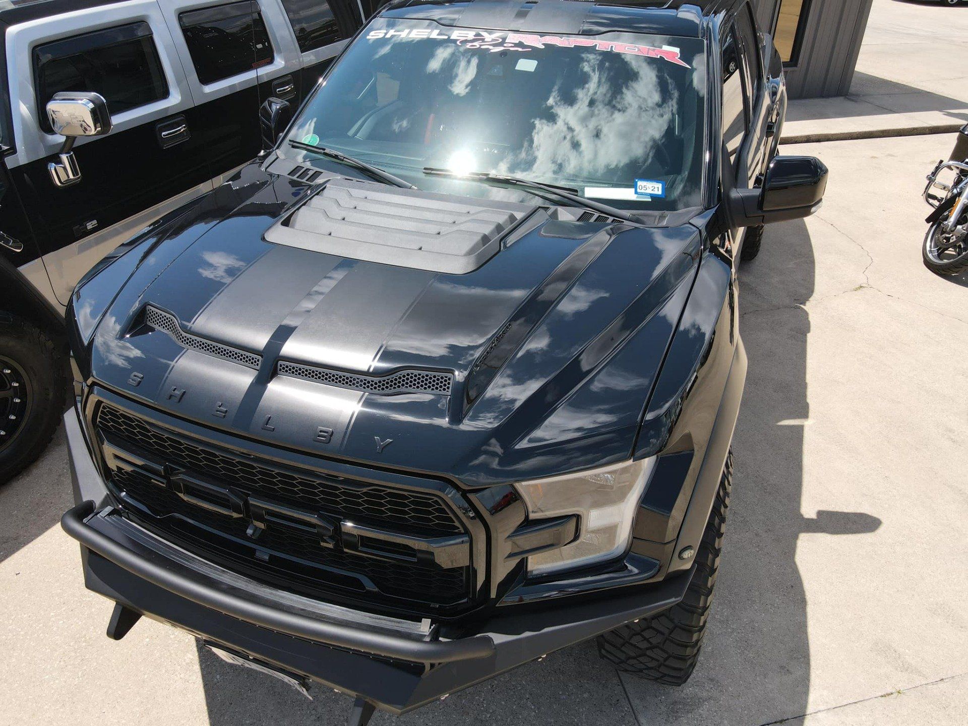 A black ford raptor is parked in a parking lot