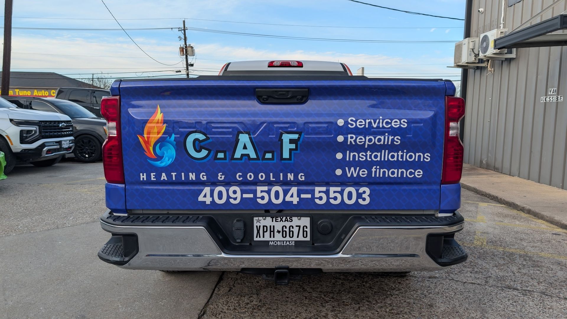 Blue pickup truck advertising C.A.F. Heating & Cooling with contact info.