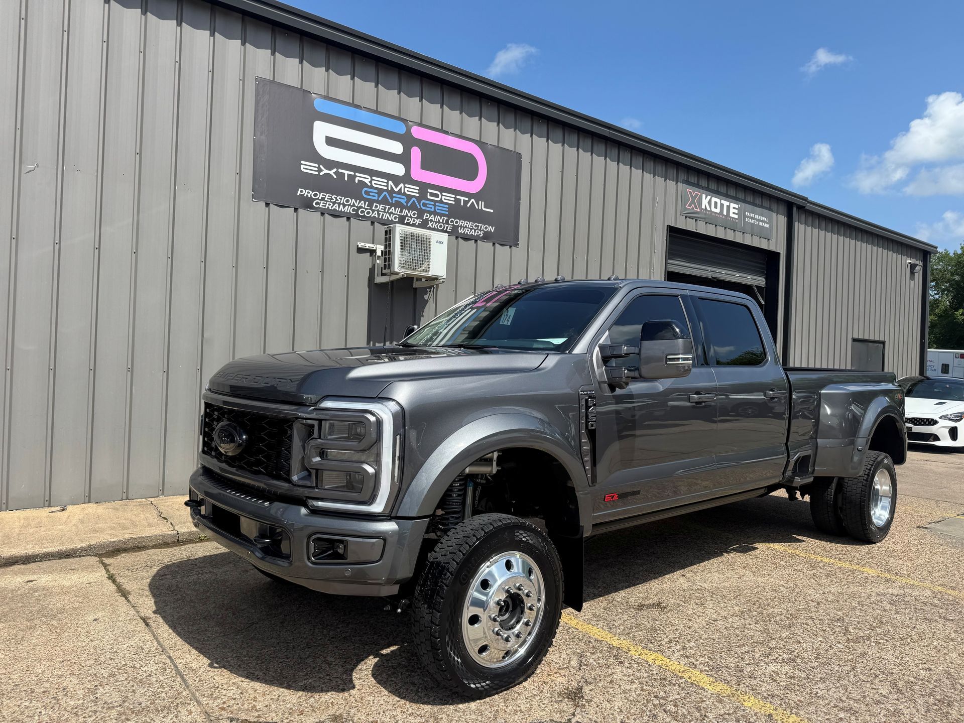 A gray truck is parked in front of a building.