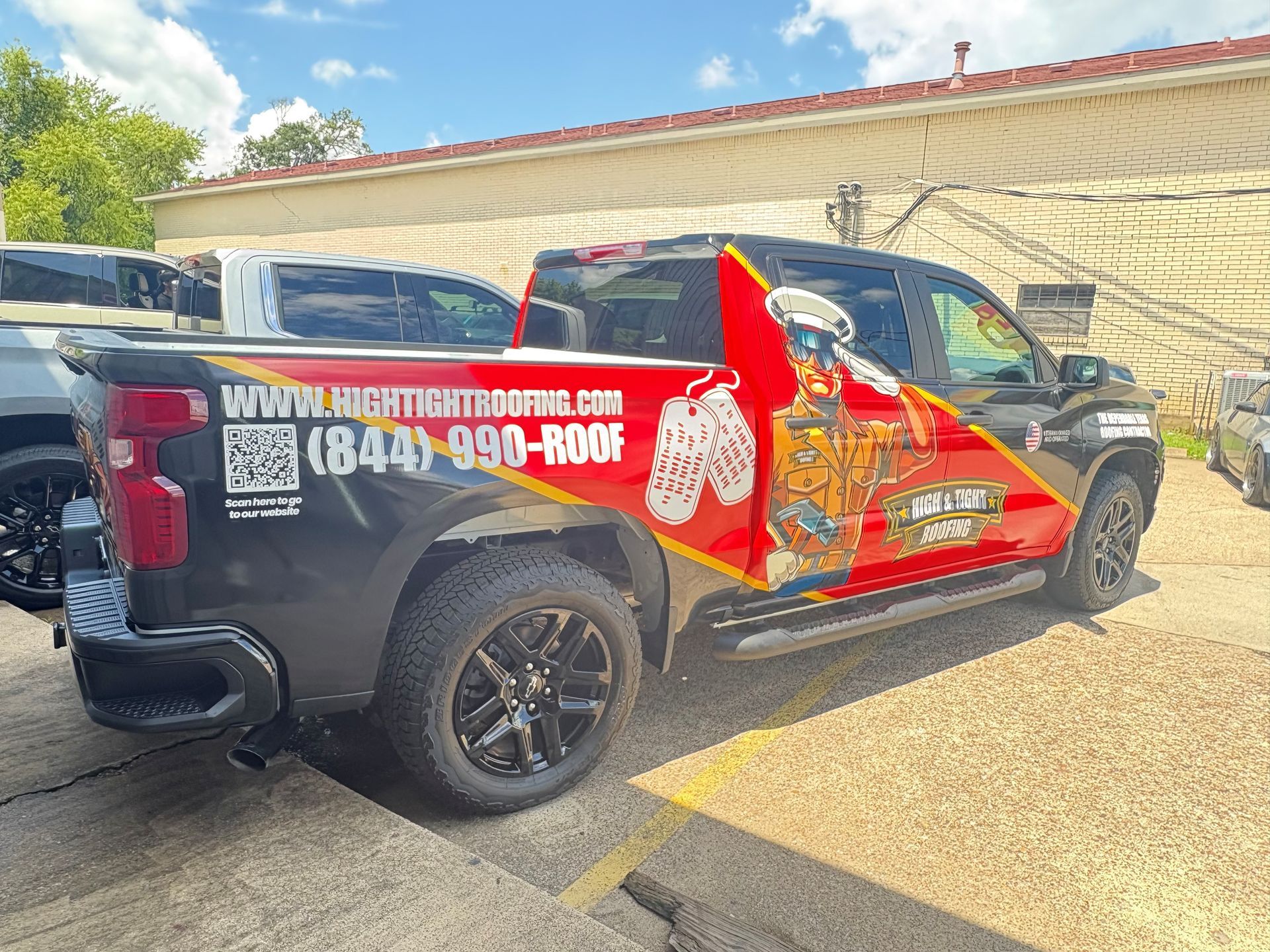 A truck is parked in a parking lot in front of a building.