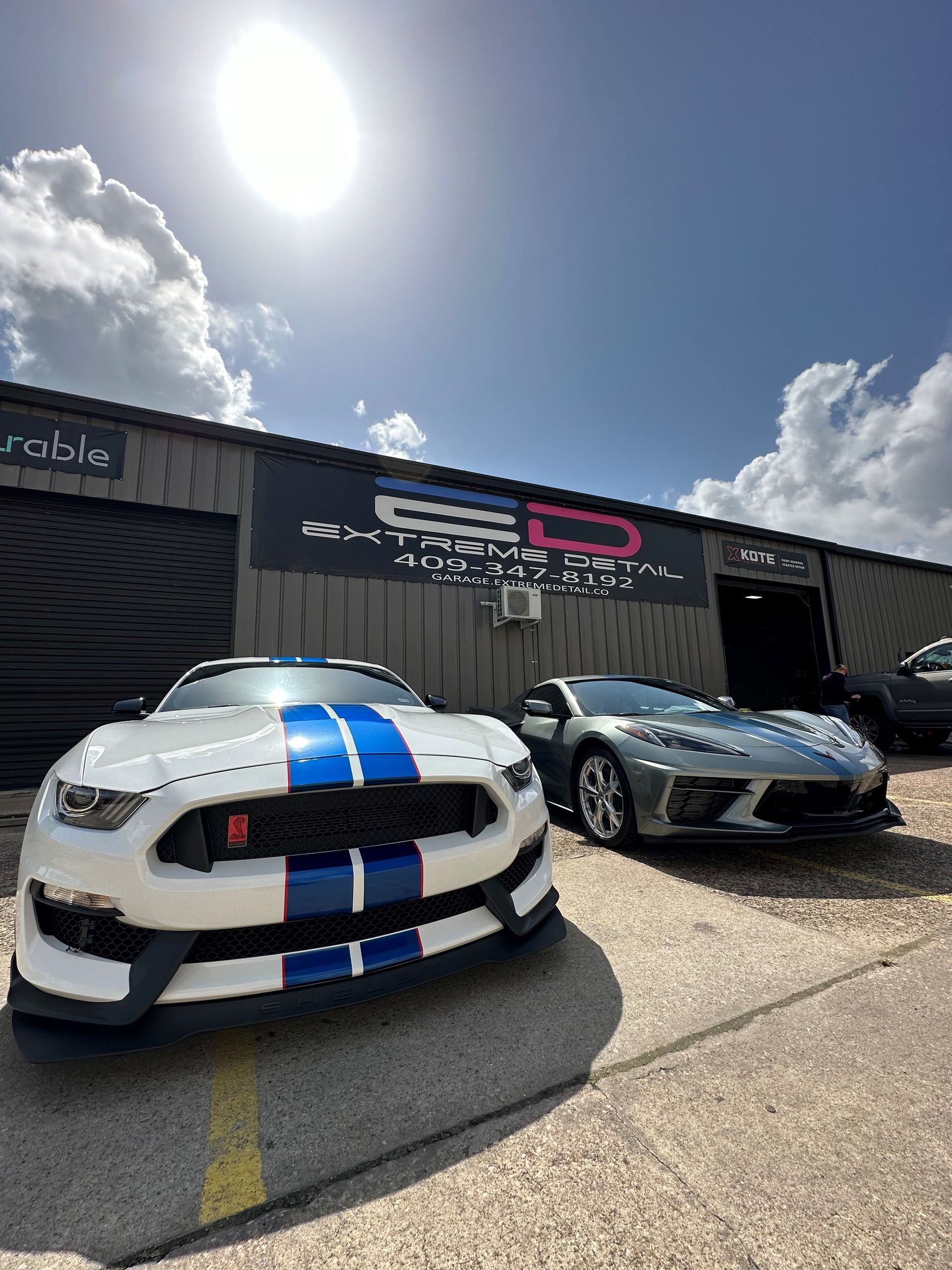 Two sports cars are parked in front of a building.
