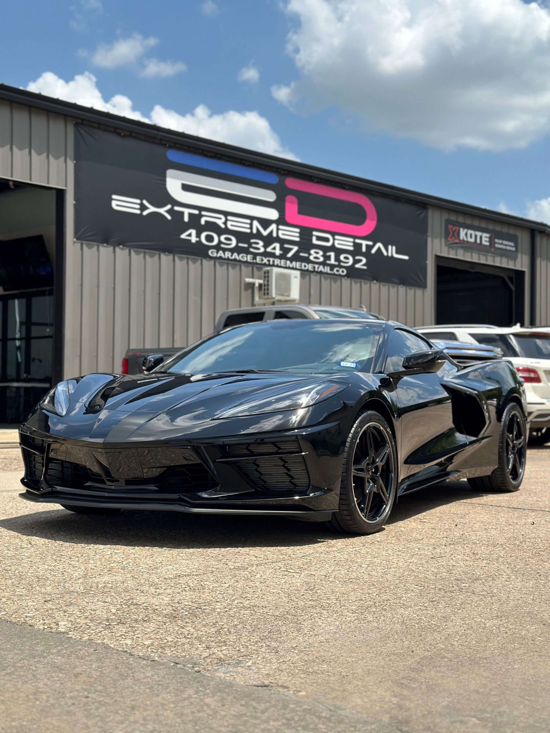 A black sports car is parked in front of a building.