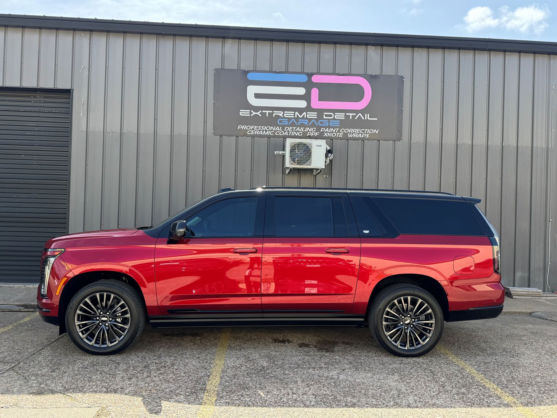 A red suv is parked in front of a building.
