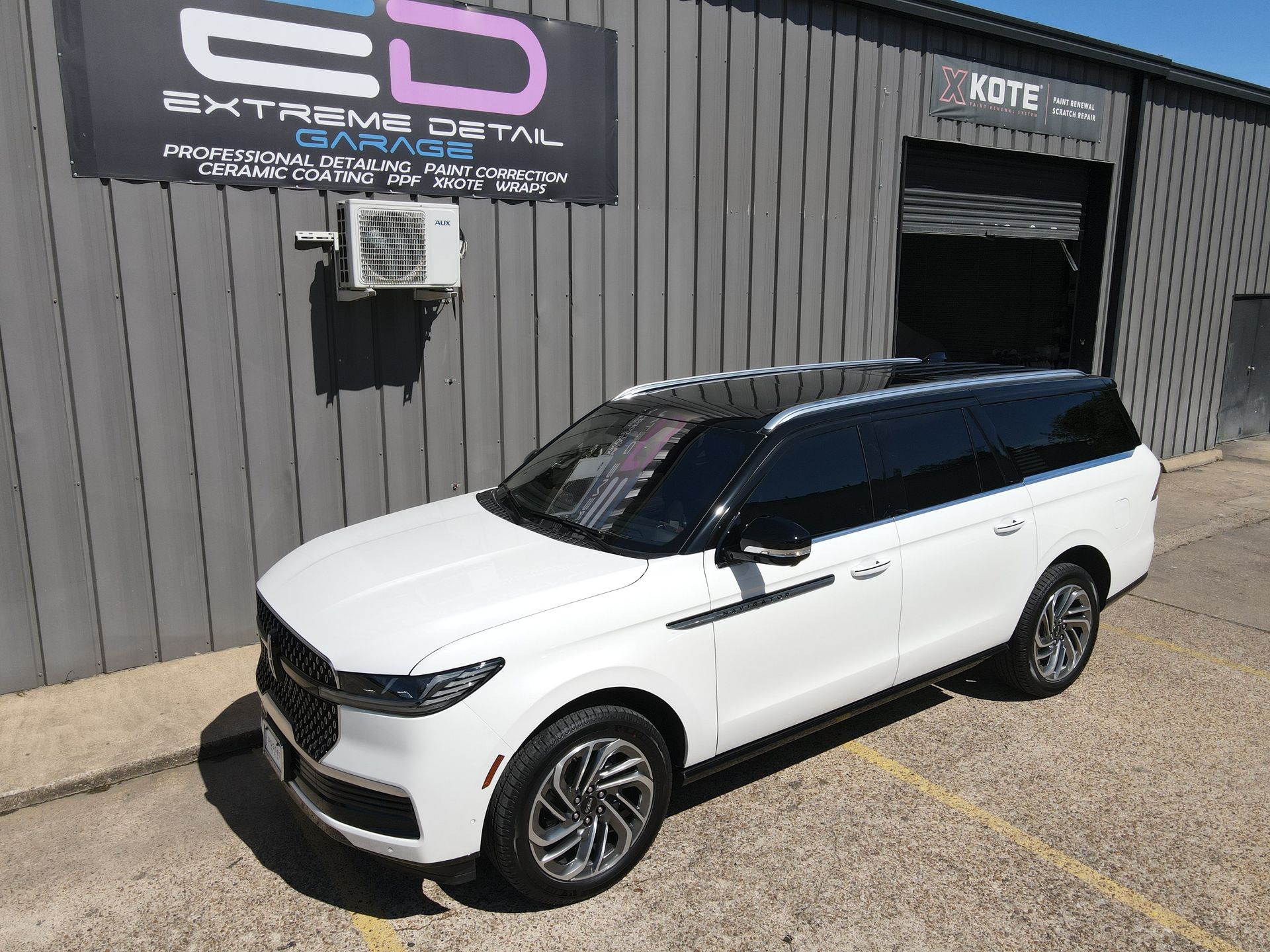 A white suv is parked in front of a building.