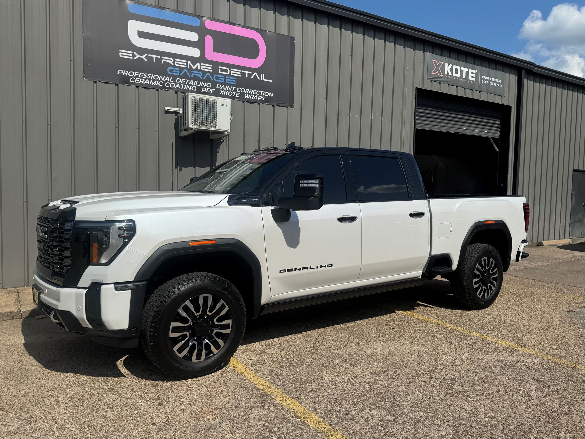 A white truck is parked in front of a building.
