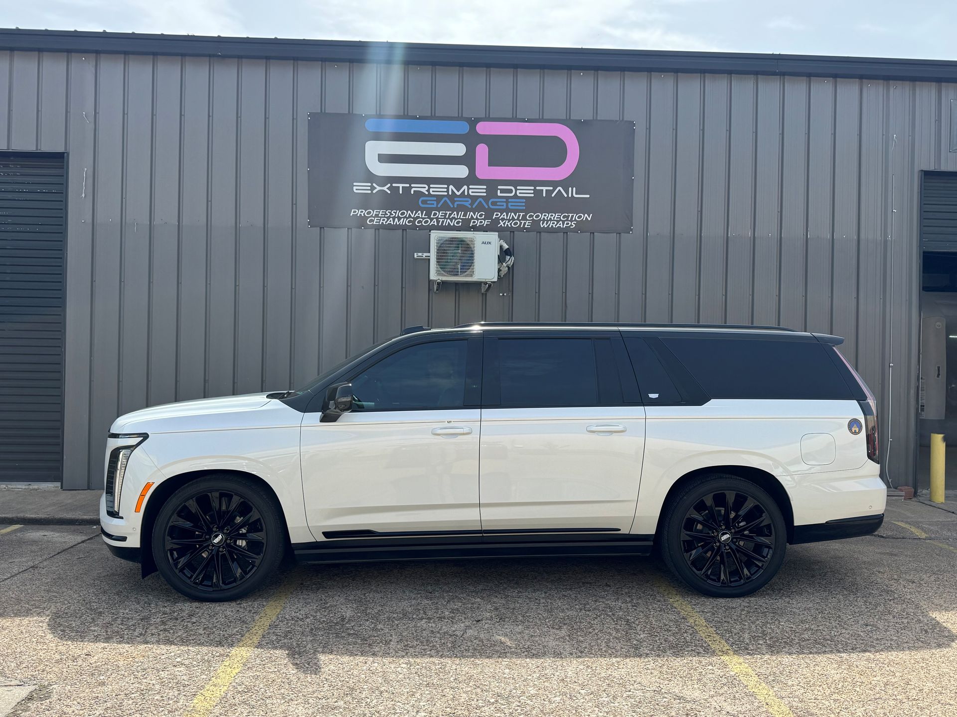 A white suv is parked in front of a building.