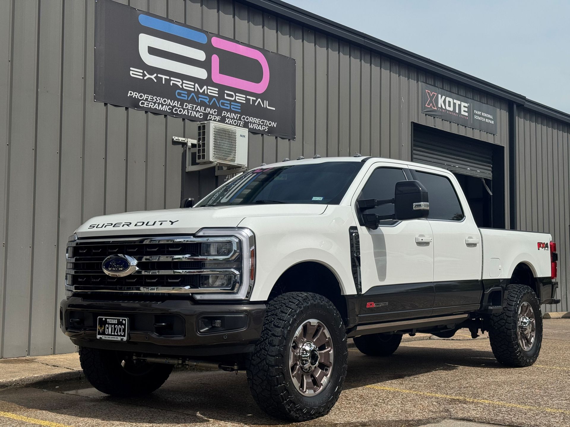 A white pickup truck is parked in front of a building.