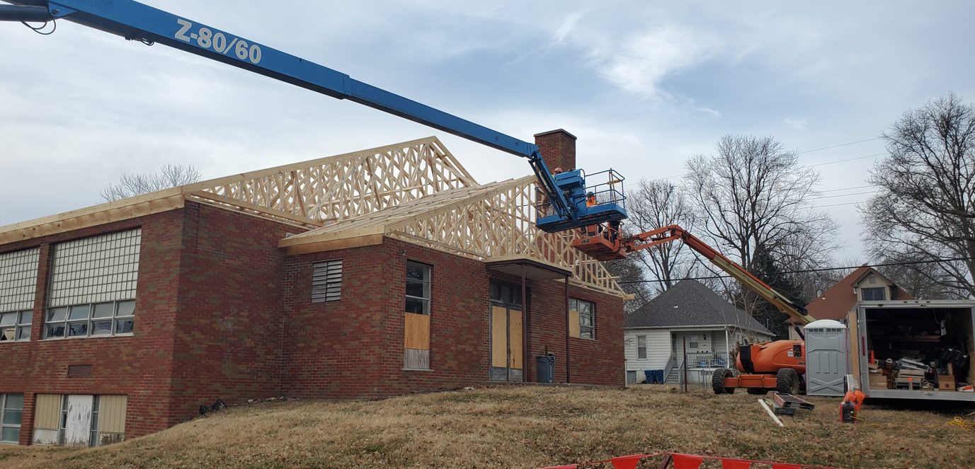 A house is being built with a crane on top of it.