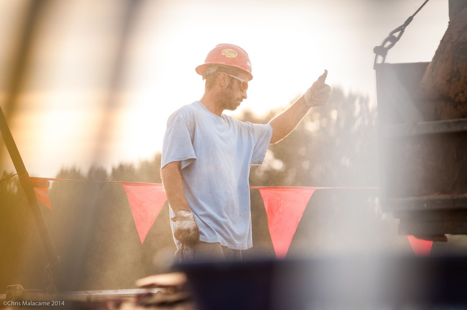 A construction worker wearing a hard hat is giving a thumbs up.