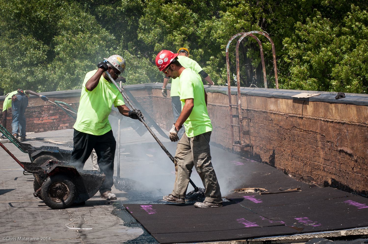 A group of construction workers are working on a roof.