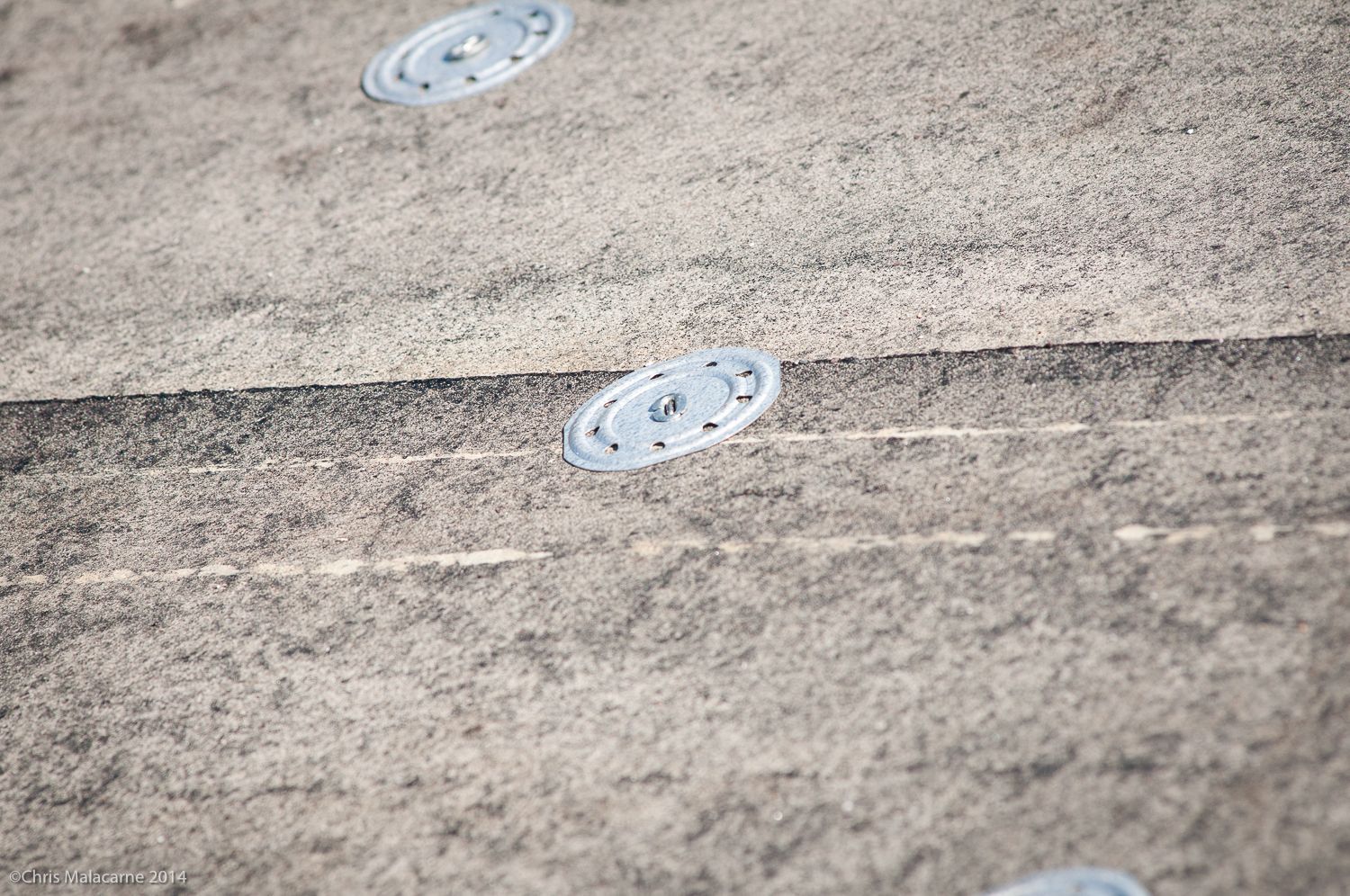 A close up of a concrete surface with screws on it.