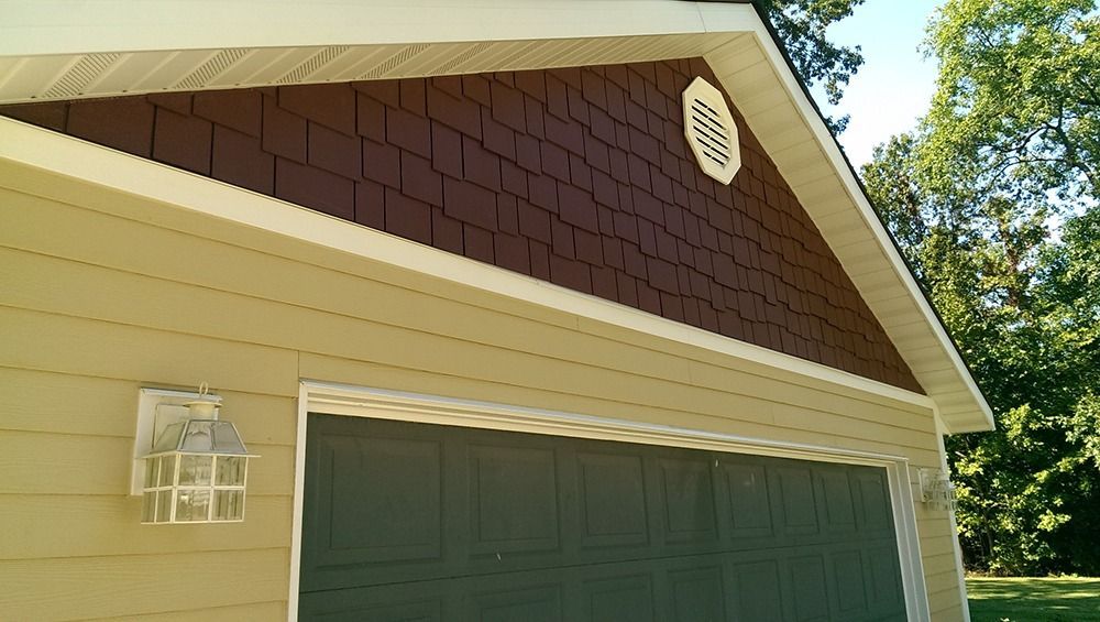A garage with a brown roof and a green door