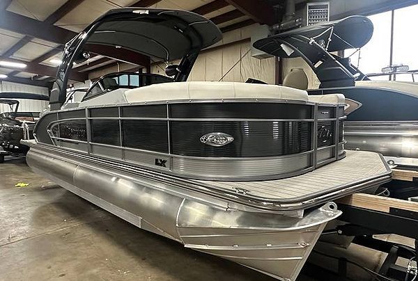 A shiny, silver and black pontoon boat inside a building.