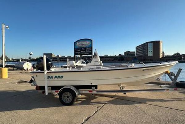 White Sea Pro fishing boat on a trailer, parked on a dock. City buildings in the background.