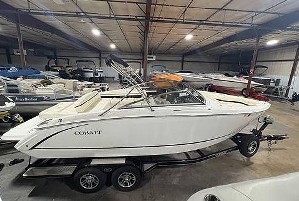 White Cobalt boat on a trailer inside a building with other boats.