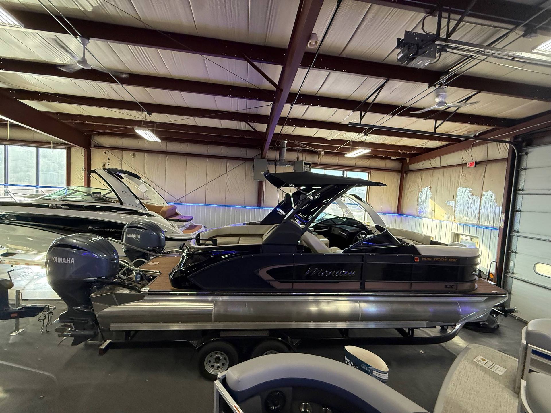 Pontoon boat inside a garage, with blue and brown details.