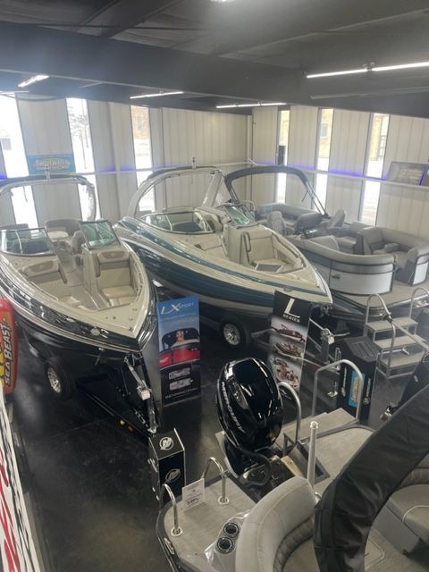 Boats on display in a showroom. Three boats are visible; white and blue, and gray colors.