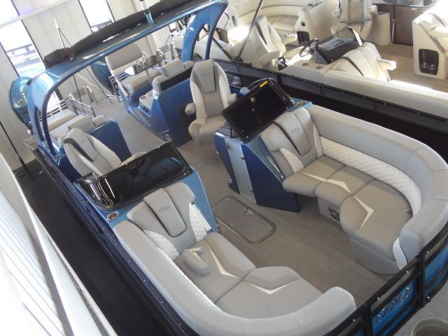 Blue and gray pontoon boat interior with seating, console, and windshield.