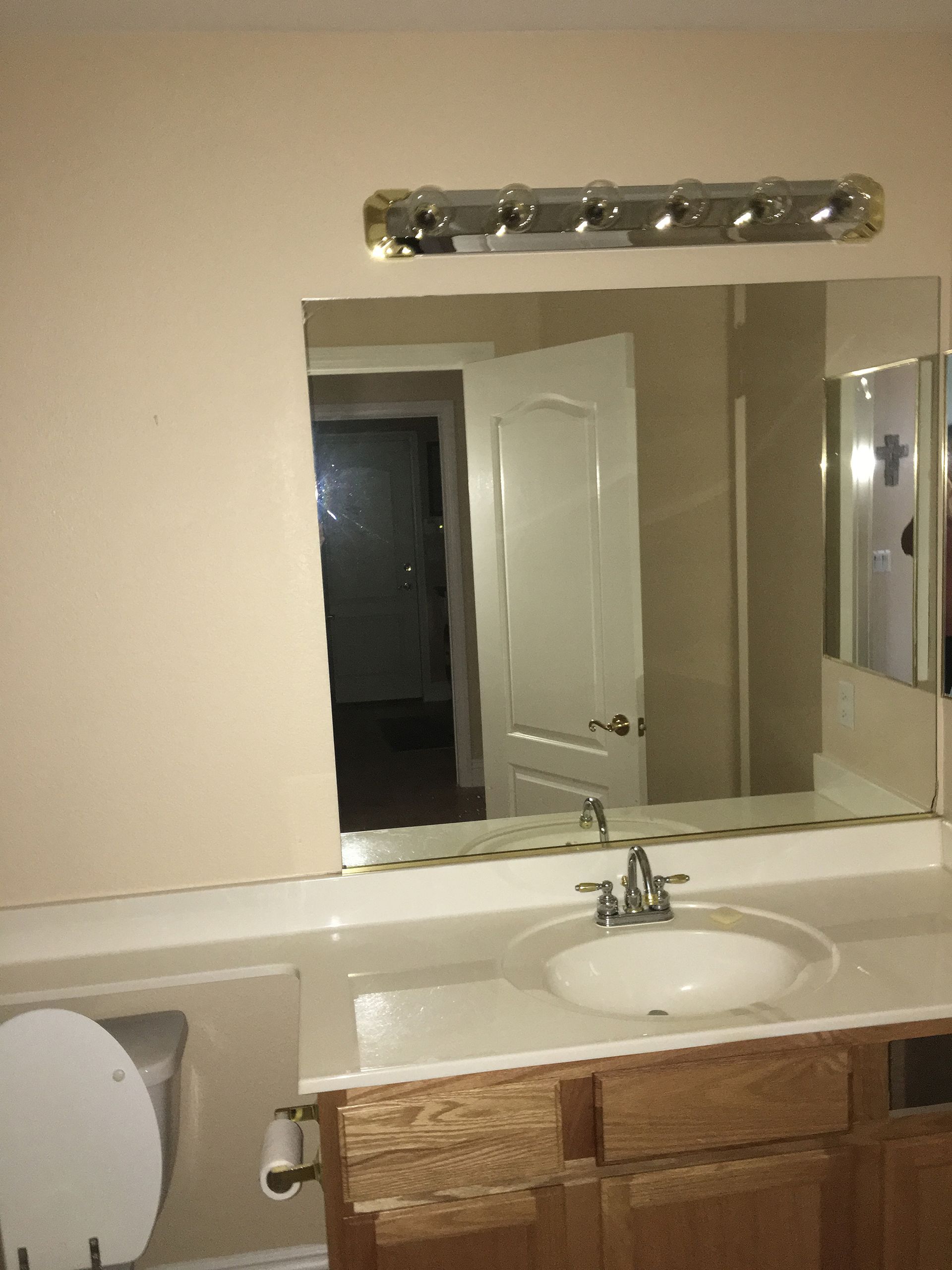 A bathroom with a sink a toilet and a mirror