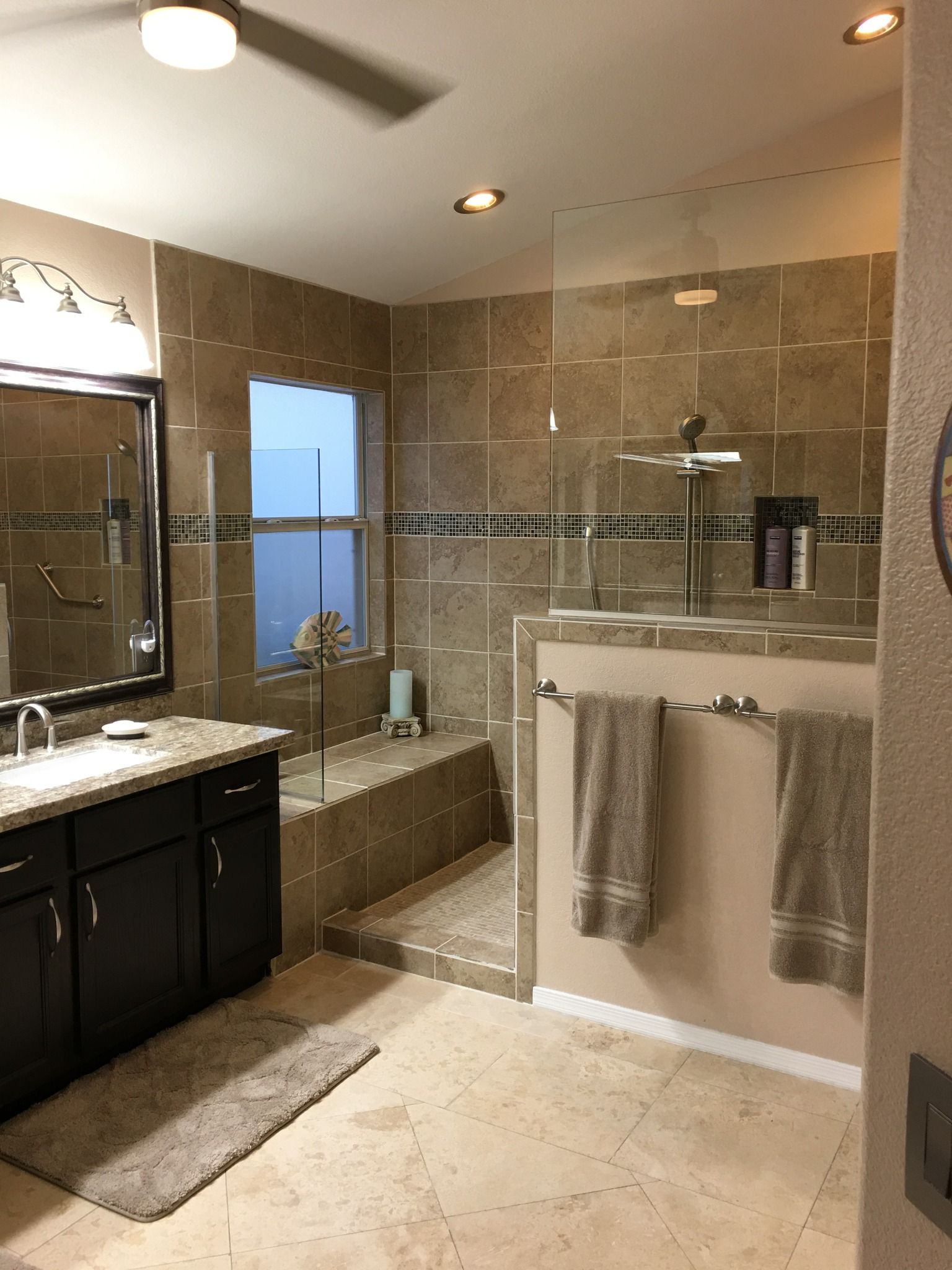 A bathroom with a walk in shower , sink , and mirror.