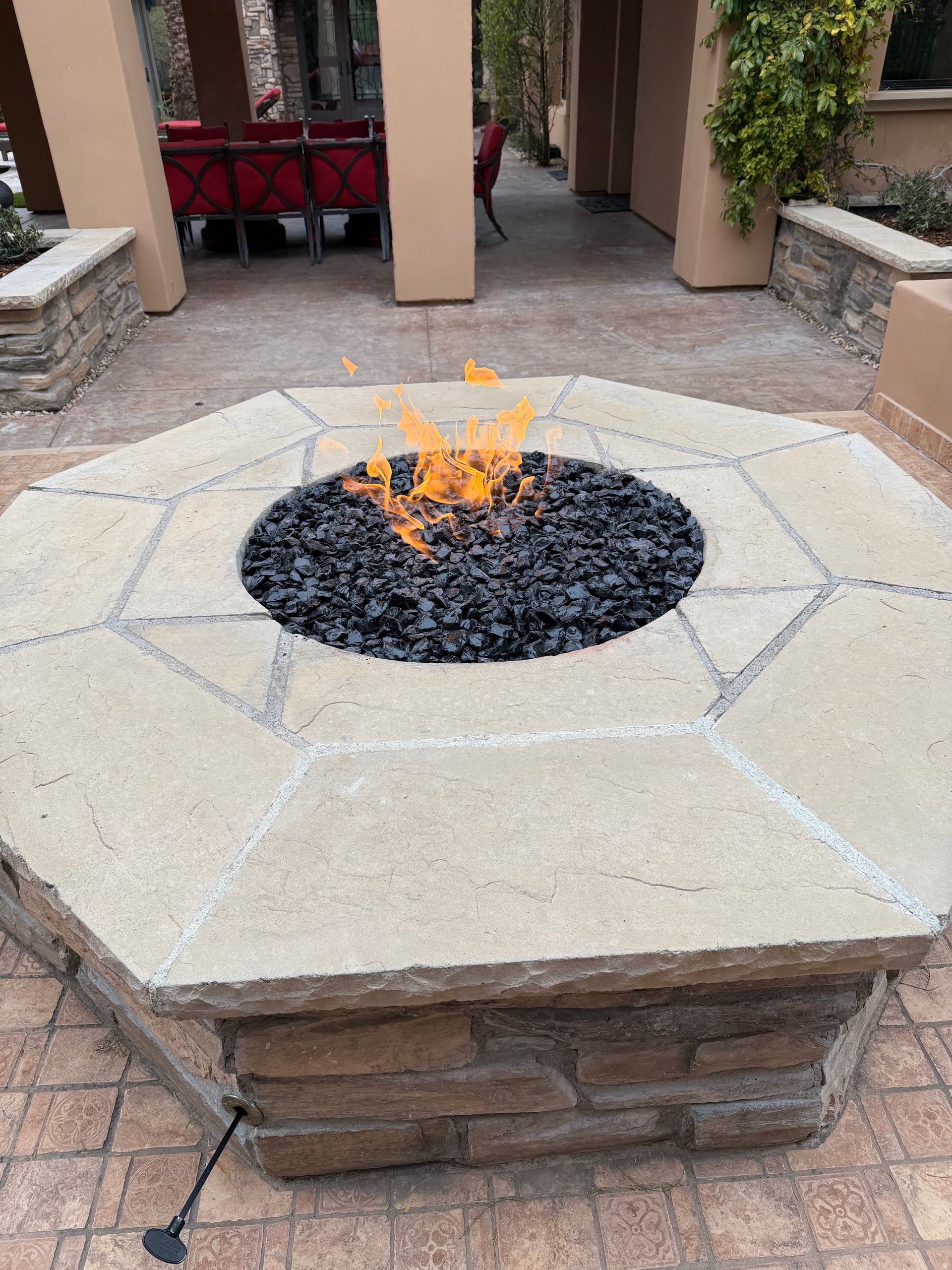 A fire pit is sitting on top of a brick patio.