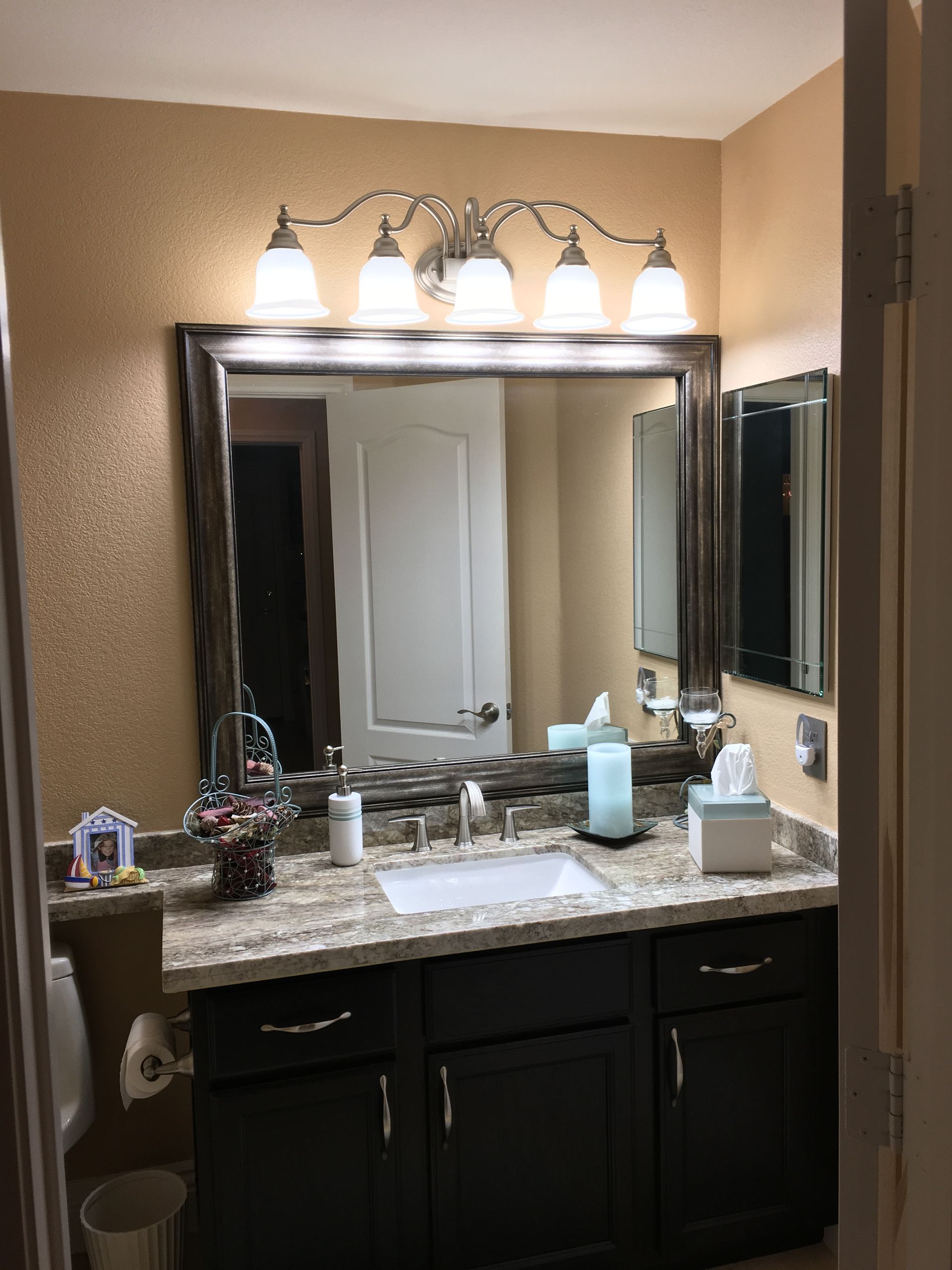 A bathroom with a large mirror and a sink.