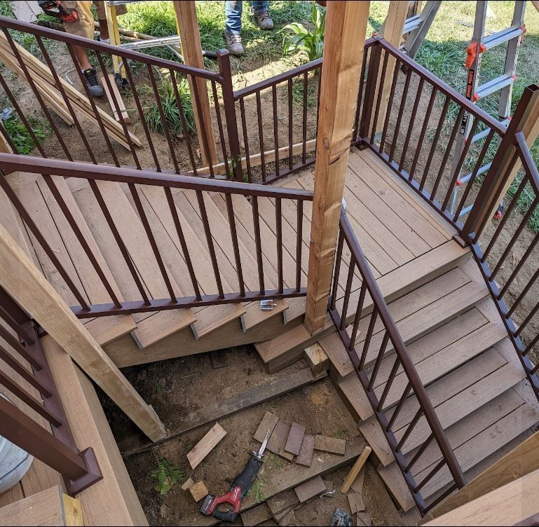 A wooden deck with stairs and a metal railing