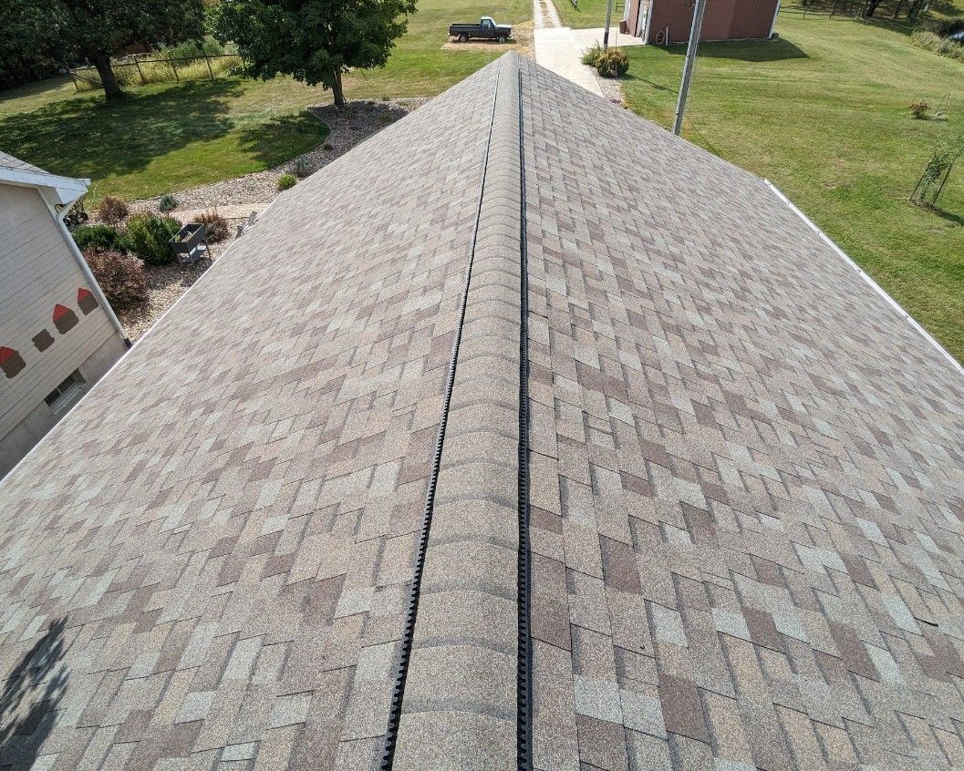 An aerial view of a roof with shingles and a gutter.