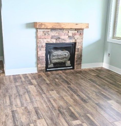A living room with a fireplace and a wooden floor