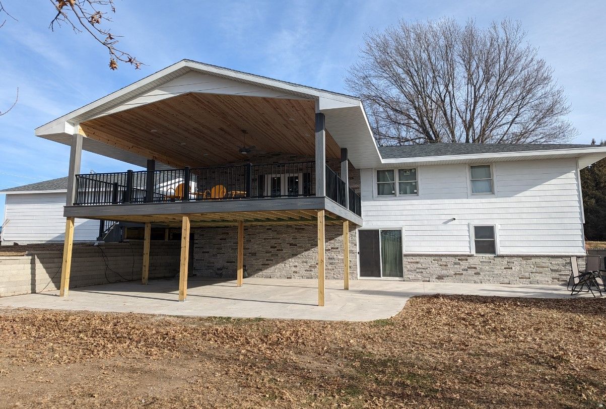 A large white house with a large deck and patio