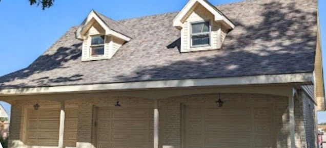 A house with a large porch and a gray roof