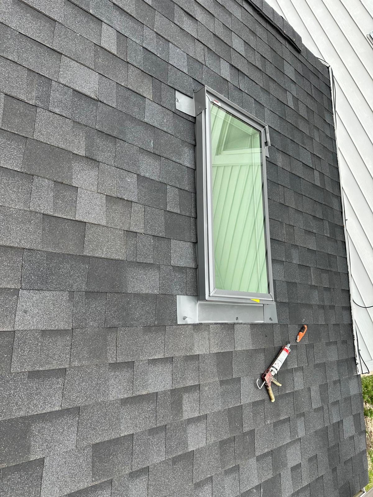 A skylight is being installed on the side of a house